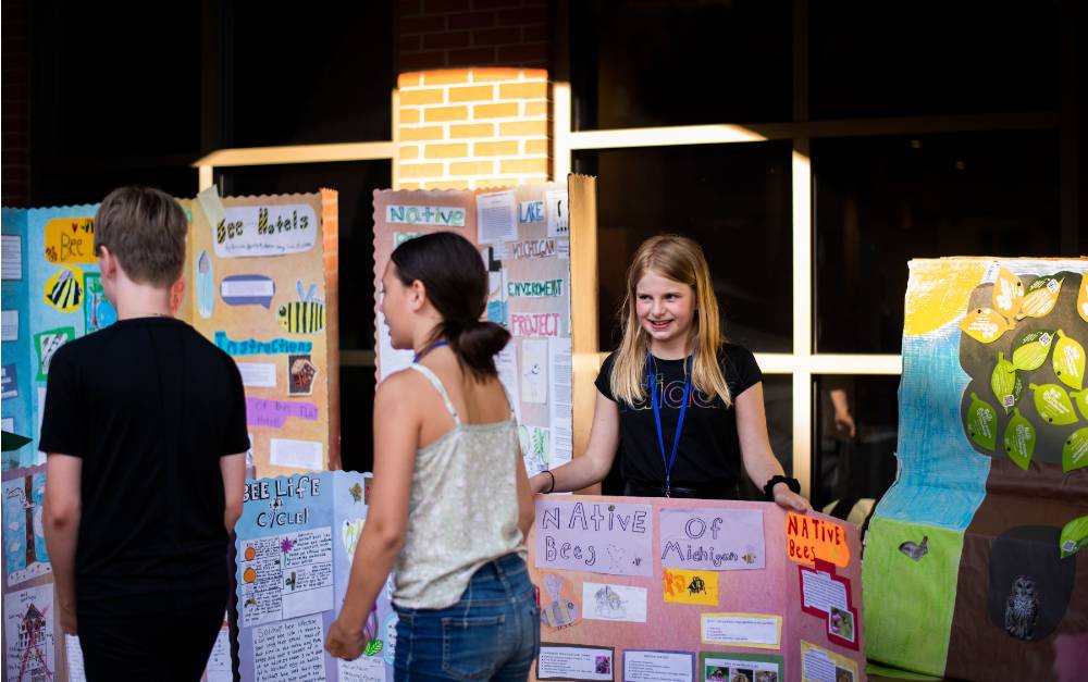 Student showing off presentation board.